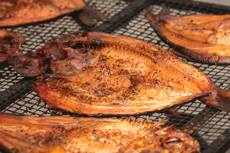 Close-up of smoked fish fillets on a grill or drying rack in a farmer street market in Vilnius,...