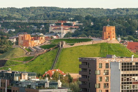 Cityscape of Vilnius, Lithuania with Gediminas Castle Tower on a green hill surrounded by...
