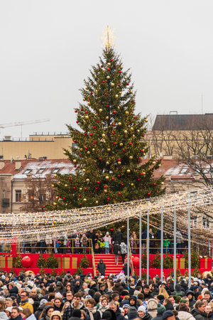 Vilnius, Lithuania - November 30 2025: A brightly lit Christmas tree in a festive city square in Vilnius, Lithuania, Europe, during the day, surrounded by people, holiday lights aのeditorial素材
