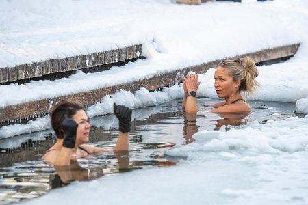 Vilnius, Lithuania - January 11 2026: Beautiful blonde hair woman immersed in the freezing cold water of a lake practicing cold water swimming. Wim Hof Method, cold therapy, breathのeditorial素材
