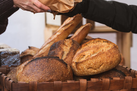 Freshly baked various types of bread displayed in wicker baskets at a bakery or street food marketの写真素材