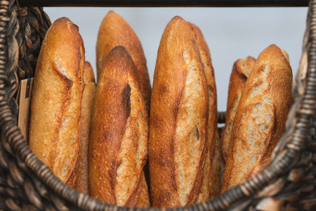 Freshly baked baguettes displayed in wicker baskets at a bakery or street food market