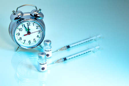Time flies to discover a Covid-19 vaccine. Concept with an alarm clock.の写真素材