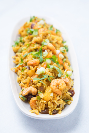 Long view of spicy seafood fried rice meal with vegetables, nuts and pineapple. Orange seafood...