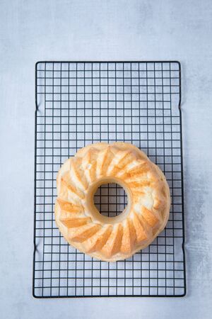 Freshly baked whole bundt cake on top of wire rack and light grey background.の写真素材
