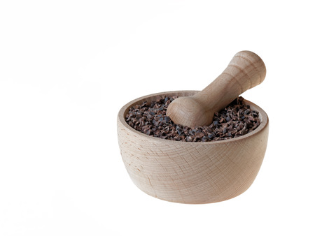 Cacao nibs in pestle isolated on whiteの写真素材