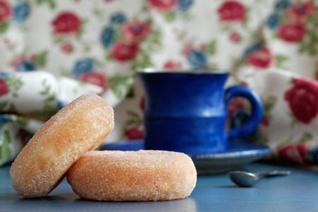 Donuts with blue coffee cup in the backgroundの写真素材