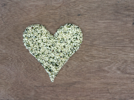 Shelled hemp seeds shaped in a heart symbolの写真素材