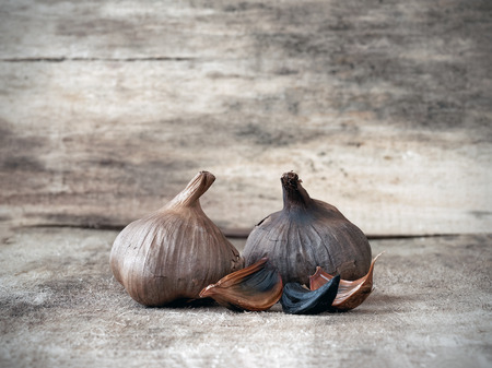 Fermented black garlic bulbs and clovesの写真素材