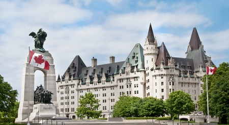 The National War Memorial with Canadian flags and the Fairmont Chateau Laurier Hotel in downtown Ottawa のeditorial素材