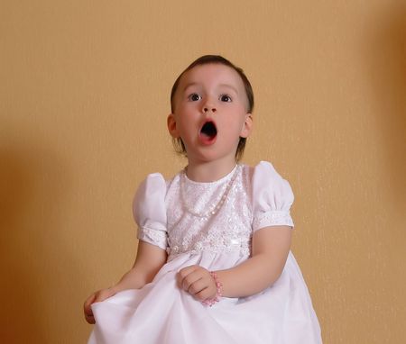 singing Girl in a white dress at light brown backgroundの写真素材