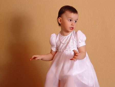 singing Girl in a white dress at light brown backgroundの写真素材