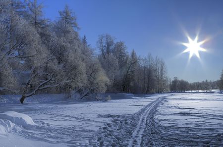 Snow ski road on a frozen lake and Sun backlight. North of Russia