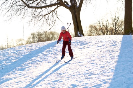 Girl enjoying cross-country skiing down in sunny dayの写真素材