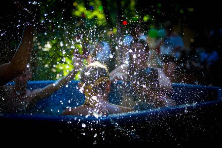 Waterdrops splashing with people in the background in a hottub