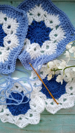 Blue, white crochet elements and orchid. Crochet texture, place for an inscription, adapted for mobileの写真素材