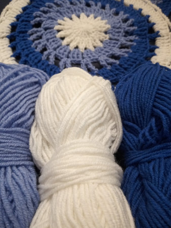 Blue, white round crochet elements and balls of yarn. Crochet texture, place for an inscription,...
