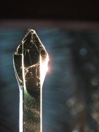 Close-up shot of golden sunlight reflecting off the sharp tip of a gate