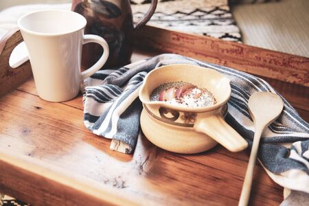 A small bowl of cereal covered with Chia seeds, dried coconut flakes, flax seed and slices of fresh fruit. The ambience from the window light gives finishing touchの写真素材