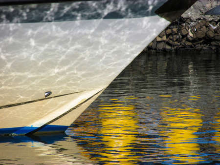 Reflection of calm sea water on a boat's bow as if the boat has multiple tiny cracks. Suitable illustrate optical illusion caused by water on science books or as a background for travel magazines.の写真素材