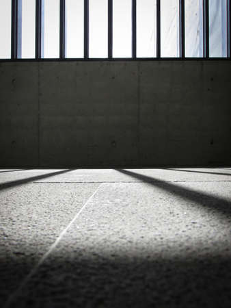 Empty corner of a concrete building. The window is framed by timbers with evenly spaced gaps for...