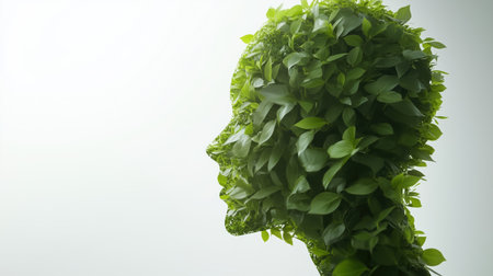 Side profile of a human head covered with vibrant green leaves. Concept of nature, sustainability, and eco-consciousness.の素材