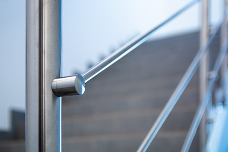 Close-up of stainless steel handrail with blurred stairs in backgroundの写真素材