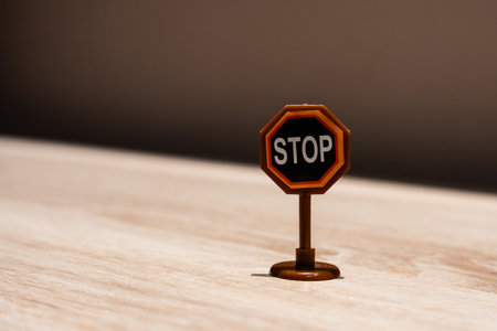 Miniature stop sign on wooden surfaceの写真素材