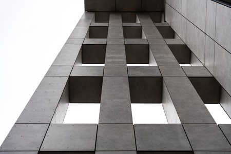 Low angle view of modern concrete building with rectangular open spaces, abstract architecture