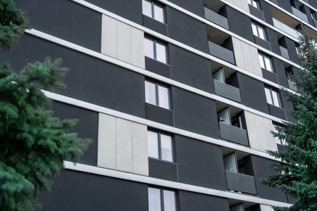 Modern apartment building with black and white facade and uniform balconies, contemporary housingの写真素材