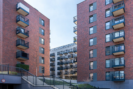 Urban residential complex with red brick and modern gray facade buildings, courtyard view in Poland