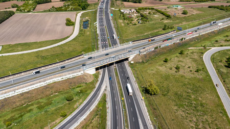 High-altitude aerial view of intersecting highways and overpass bridges showing transport routes and...
