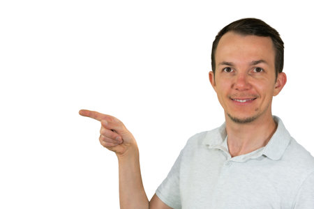 Man smiling and pointing to the side, expressing instruction or recommendation. Isolated portraitの写真素材