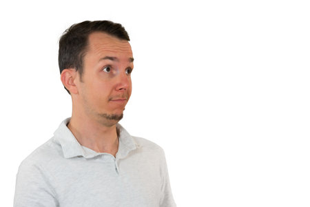 Man in white shirt looking surprised or curious to the side. reaction or concept visuals. Isolated portraitの写真素材