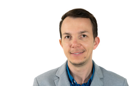 Confident man in business casual attire smiling warmly, portrait close-up on white background,...