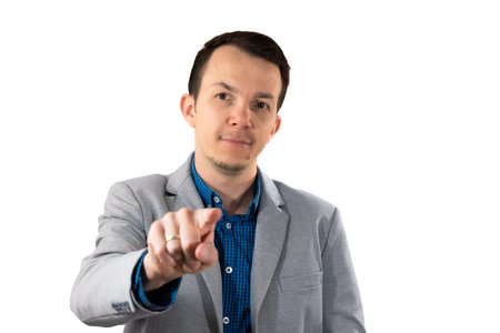 Man in light gray blazer pointing finger toward camera with confident facial expression and direct eye contact, used for assertive communication or leadership themes. Isolated portraitの写真素材