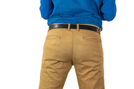 Backside view of male in tan pants and blue shirt with hands on waist, neutral stance. Isolatedの写真素材