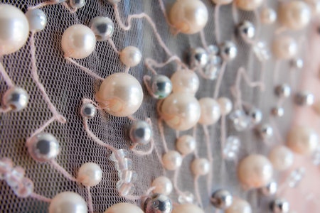 Detailed macro of mesh fabric with pearl and bead embellishments in elegant design pattern for fashion and apparel decorationの写真素材