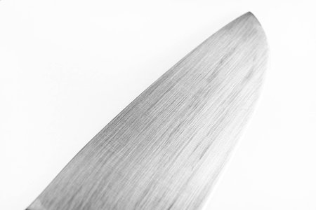 High detail close-up of stainless steel kitchen knife blade isolated on white background for...