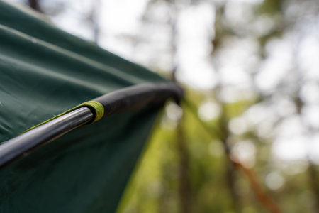 Curved Tent Pole With Green Clip Supporting Camping Tent