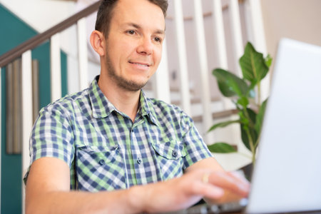 Smiling Man Using Laptop At Home Office Positive Remote Work Conceptの写真素材