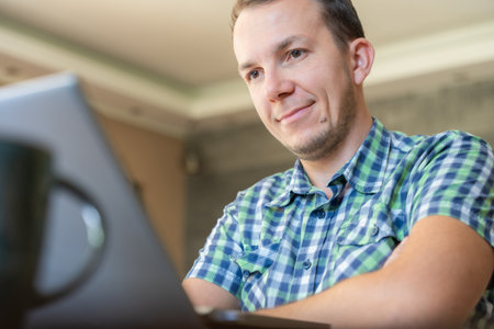 Man Smiling At Laptop In Remote Work At Home, Online Casual Learning With Technology And Productivityの写真素材