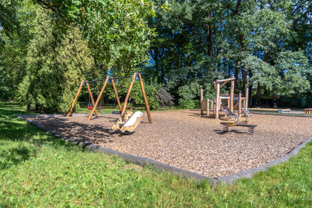 Natural Wood Playground With Swings, Slides And Seesaw In Green Park, Sunny Family Recreation Areaの写真素材