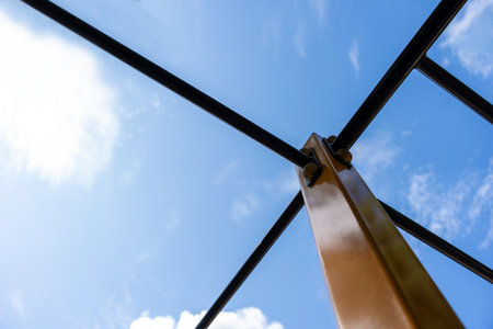 Upward View Of Calisthenics Bars And Bolted Post Against Blue Sky, Outdoor Fitness Structure Detailの写真素材