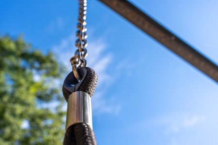 Swing Chain Connector And Metal Hardware Against Blue Sky, Safety Detail Of Outdoor Playgroundの写真素材