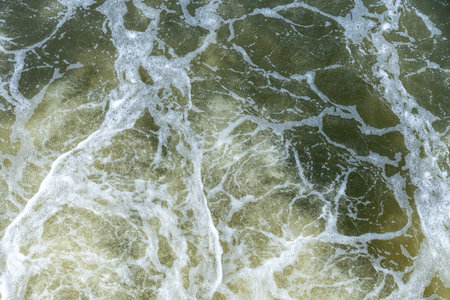 Foamy Ocean Surface With White Water Bubbles And Swirling Patterns Showing Motion Energy Of Sea...
