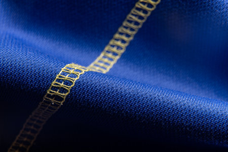 Blue Fabric Texture With Yellow Decorative Stitching Macro Closeup, Textile Background Pattern For Design Seam Detailの写真素材