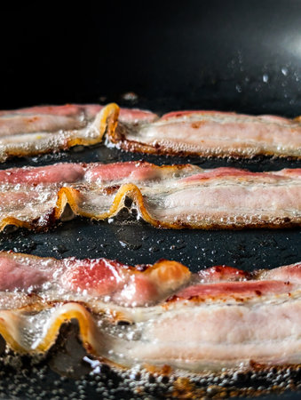 Sizzling Bacon Strips Frying In Hot Pan With Bubbling Oil Close Up View Of Crispy Breakfast Meat Food Backgroundの写真素材