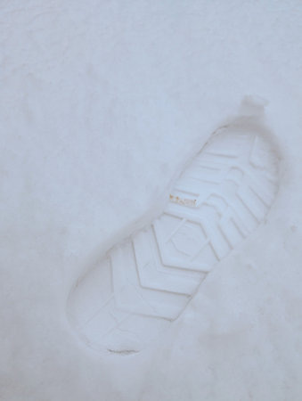 Single Boot Footprint Imprinted In Fresh White Snow Symbolizing Winter Walk Trail And Outdoor Adventure Backgroundの写真素材