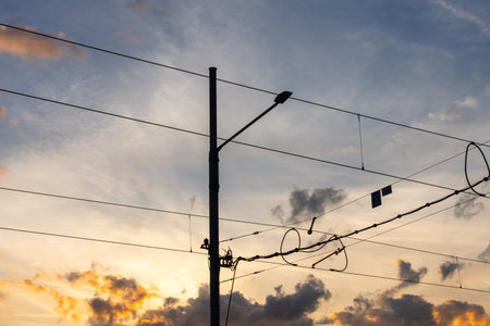 Silhouetted Wires And Street Lamp Against Colorful Sunset Sky In Urban Settingの写真素材